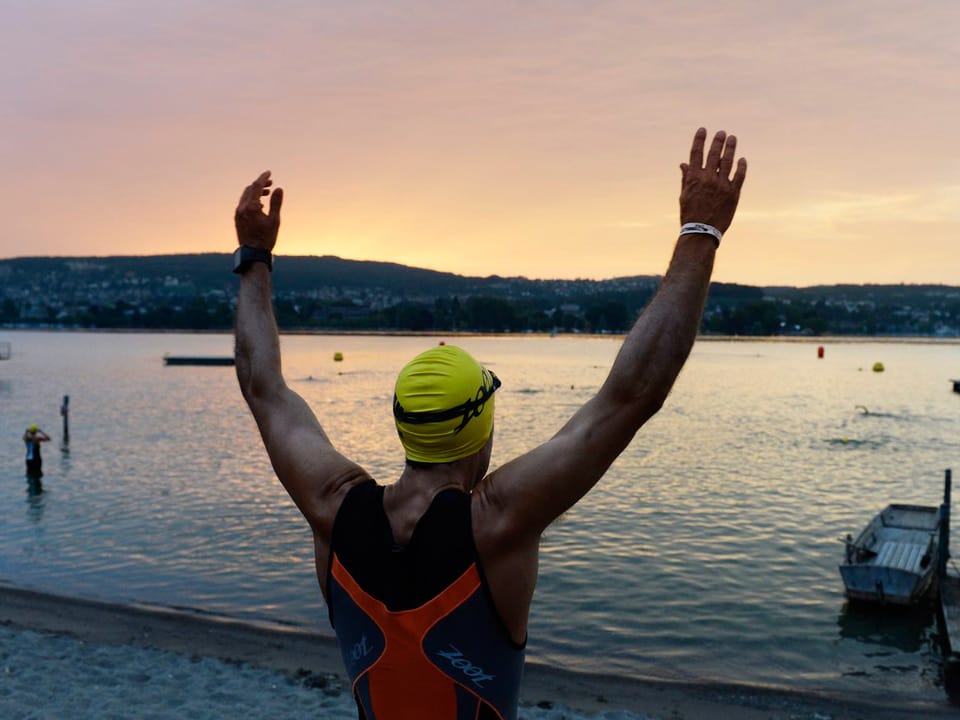 Zu sehen ist eine Schwimmer am Zürichsee im Morgengrauen.