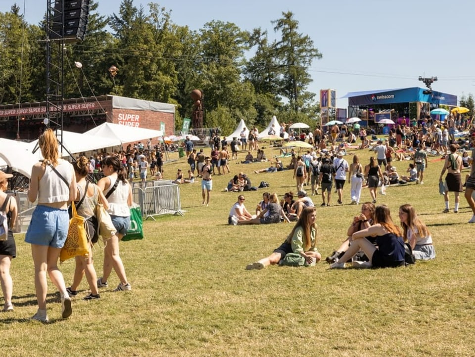 The railings in front of the main stage at the Gurten Festival.  Some people are sitting and walking.