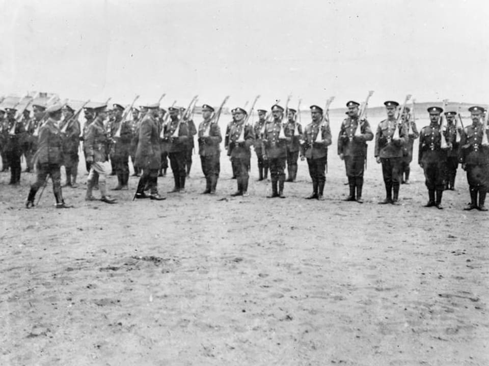 Altes Bild in Schwarz-Weiss: Soldaten stehen aufgereiht in der Wüste, 