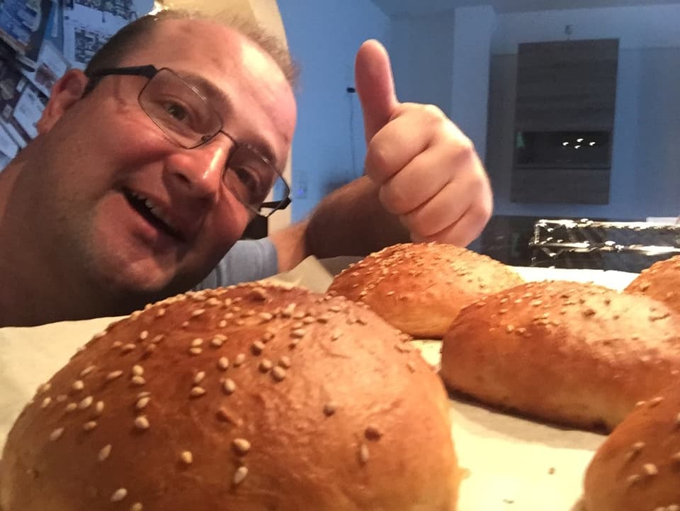 Michael Brunner posiert mit den selbstgebackenen Hamburgerbrötchen.