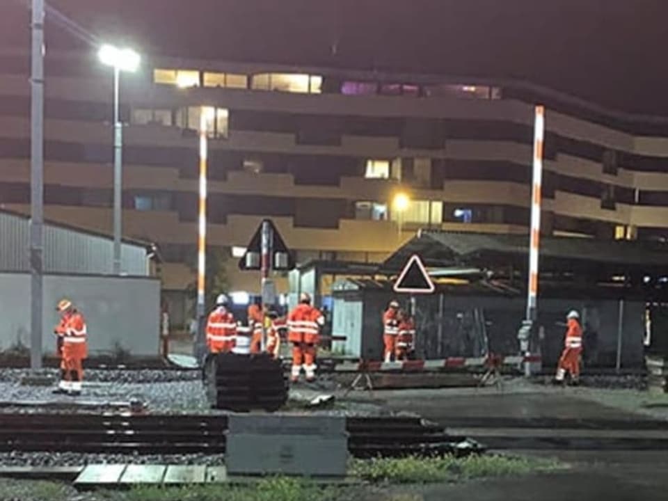 Gleisarbeiter demontieren einen Bahnübergang