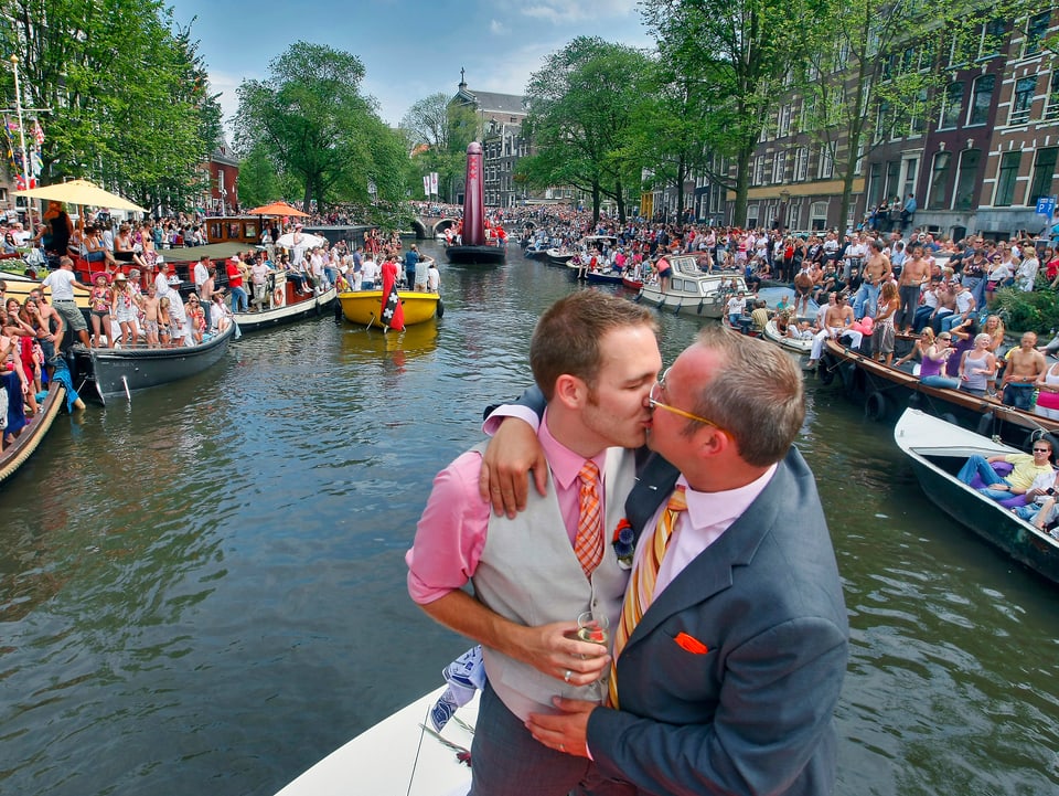 Schwules Paar küsst sich auf einem Boot in den Niederlanden