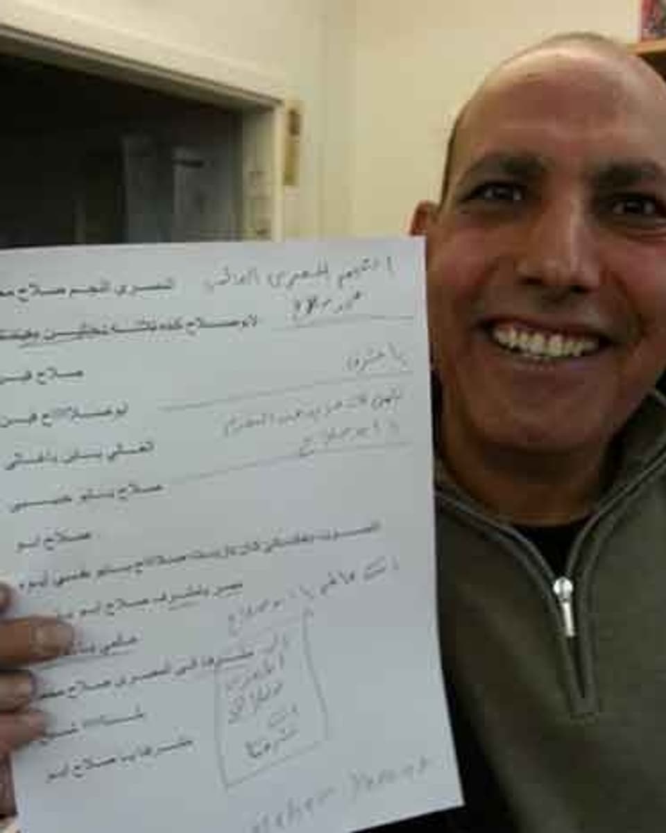 Zu sehen ist ein Ägypter, der ein A4-Papier in die Kamera zeigt. Auf dem Blatt Papier sind einige Sätze auf Arabisch.