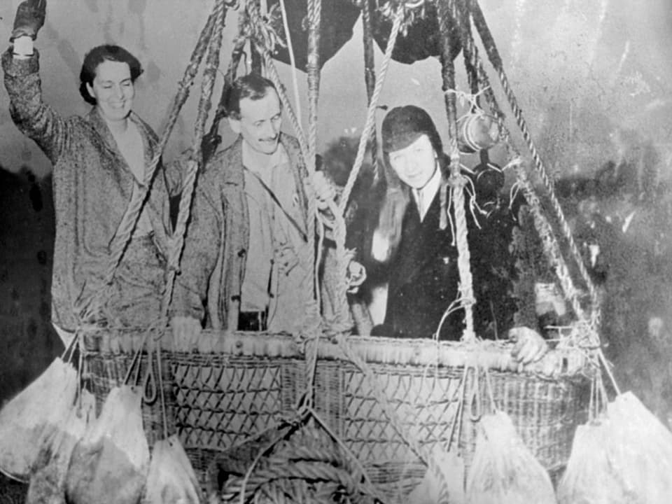 In einem Ballonkorb auf einem Schwarz-Weiss-Bild (v.l.n.r.): Jeannette Piccard, Jean-Felix Piccard und Edward J. Hill