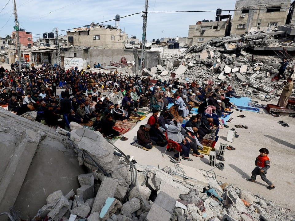 Hunderte Palästinenser knien am Boden.