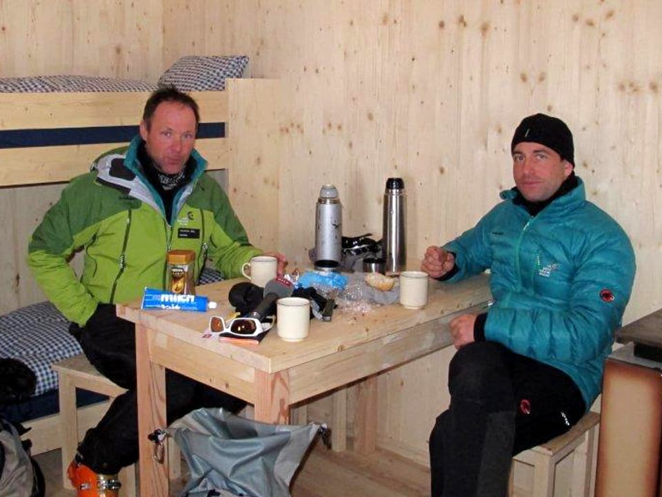 Zwei Männer in einer Holzhütte am Tisch