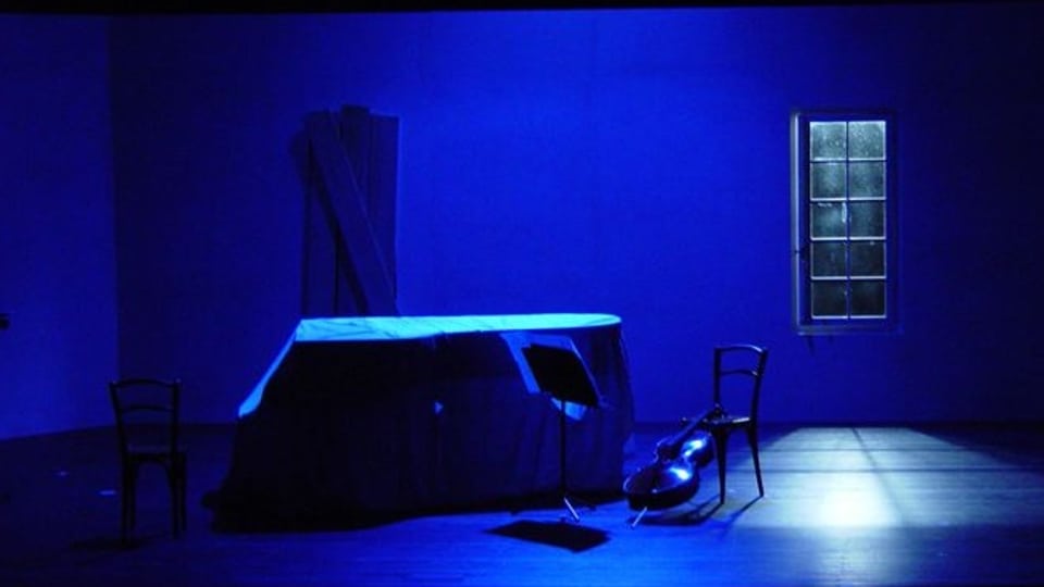 Bühnenbild eines Theaterstücks, in blaues Licht gehüllt.