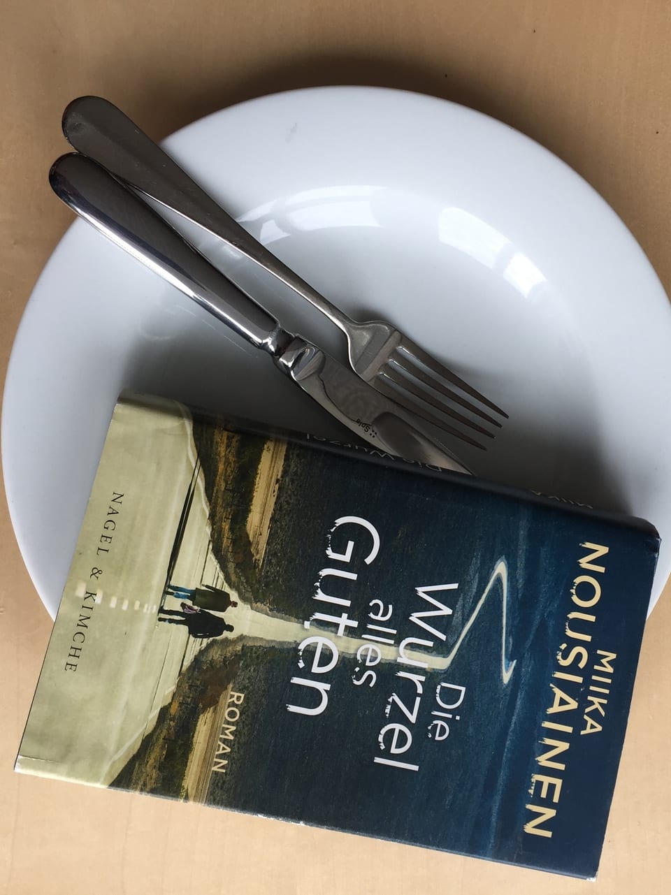 Miika Nousiainen: «Die Wurzel alles Guten» (2017, Nagel + Kimche) auf einem Teller