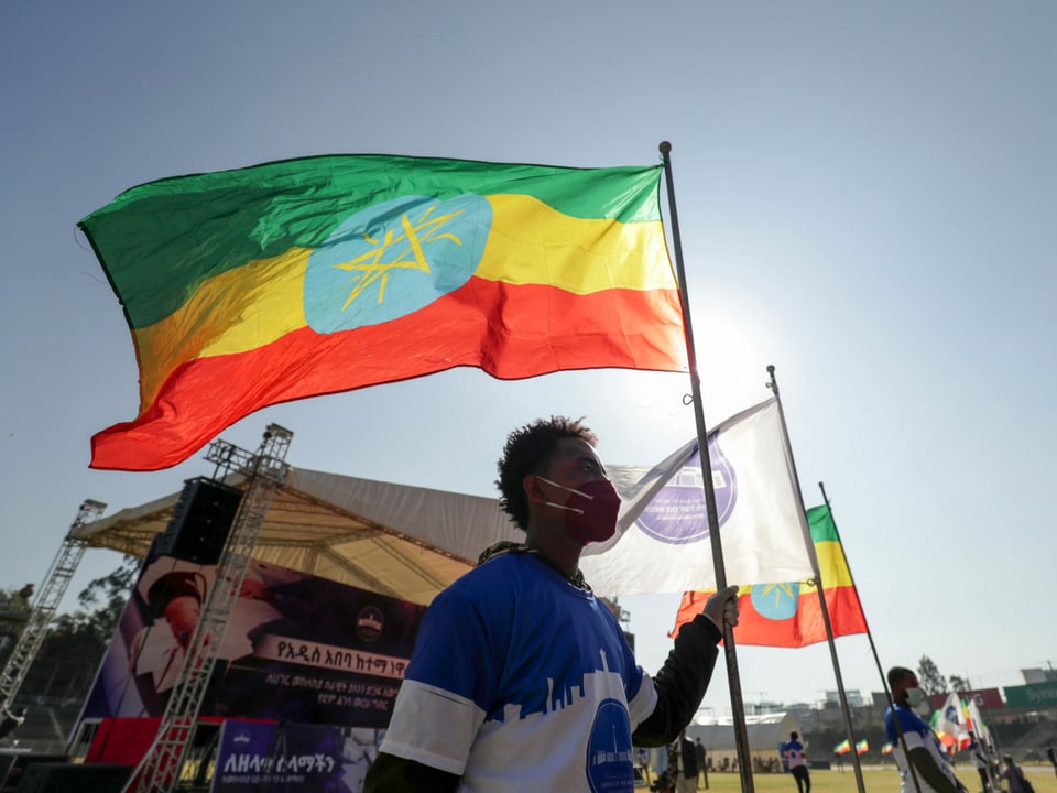 Ein Mann hält eine äthiopische Flagge. 