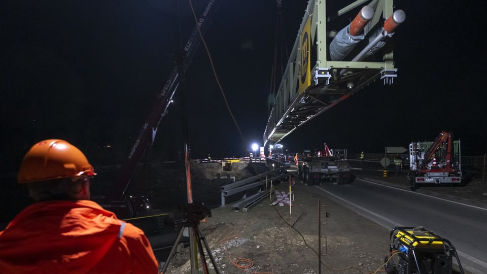 Bauarbeiter mit Helm bei der Montage einer Rohrleitungsbrücke auf der Autobahn A18 in Arlesheim.