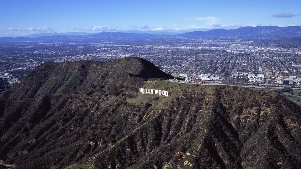 Auf dem Bild ist der bekannte Hollywood Schriftzug zu sehen, dahinter die Vorstadt Burbank.