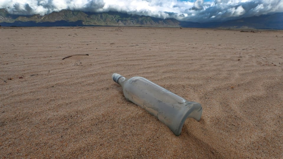 Eine Flasche in der Wüste.