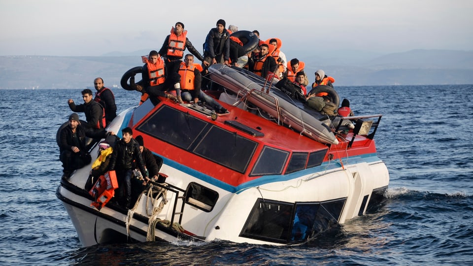 Flüchtlinge sitzen auf einem Boot, das fast am Untergehen ist 