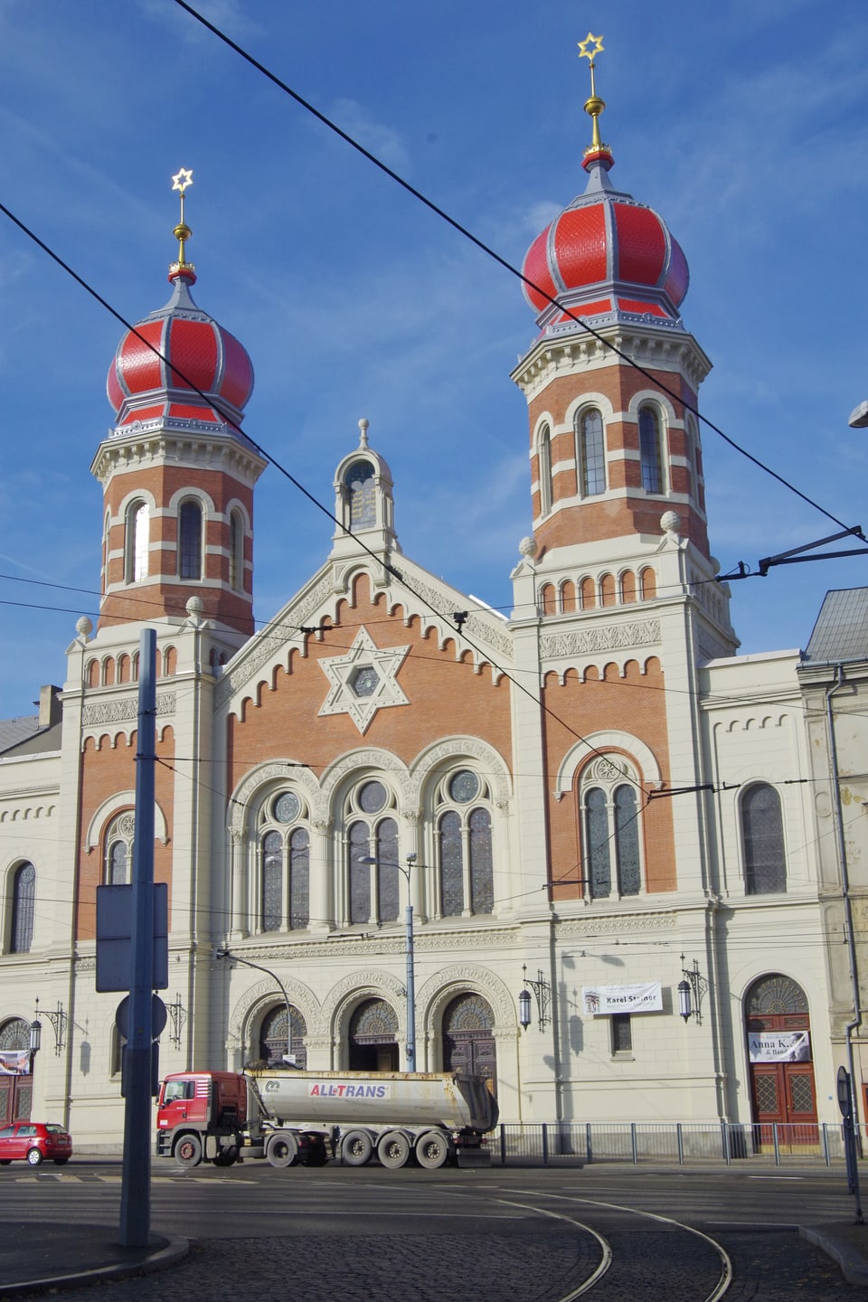 Blick auf eine Synagoge mit zwei roten Zwiebeltürmen. 