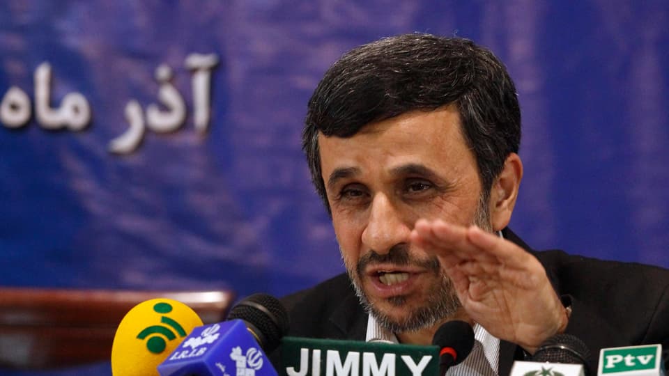 Mahmud Ahmadinedschad sitzt vor Mikrofonen und spricht zu den Medien.