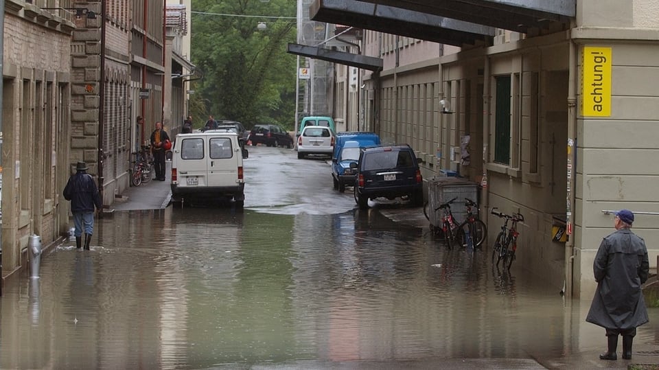 Menschen waten durch Wasser in Quartier 