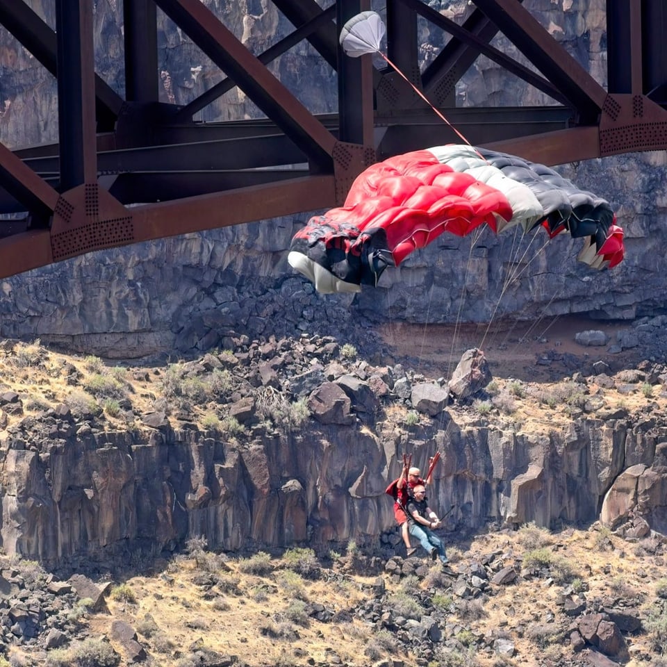 Der Fallschirm der Tandem-Basejumper öffnet sich. 
