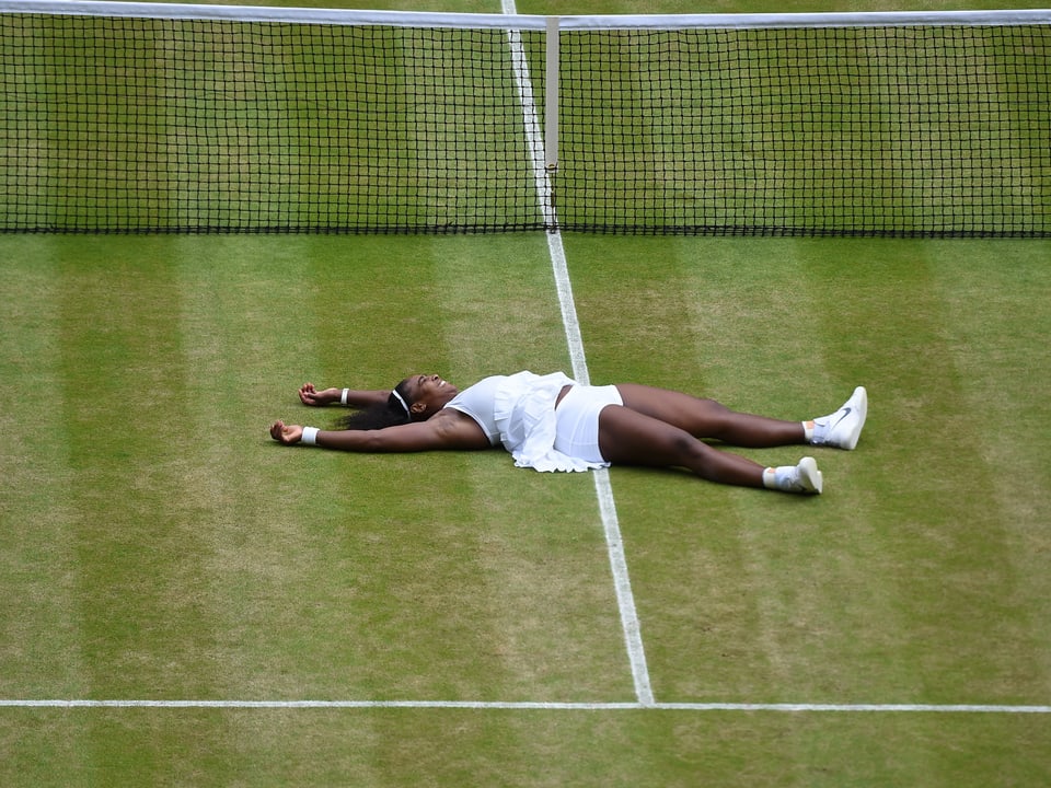 Serena Williams liegt auf dem Rasen.