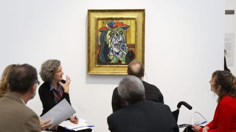 Besucherinnen sitzen vor einem Picasso-Gemälde.
