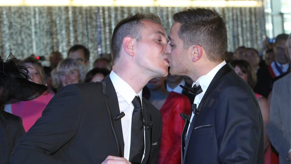 Homo-Ehepaar. Zwei Männer küssen sich.