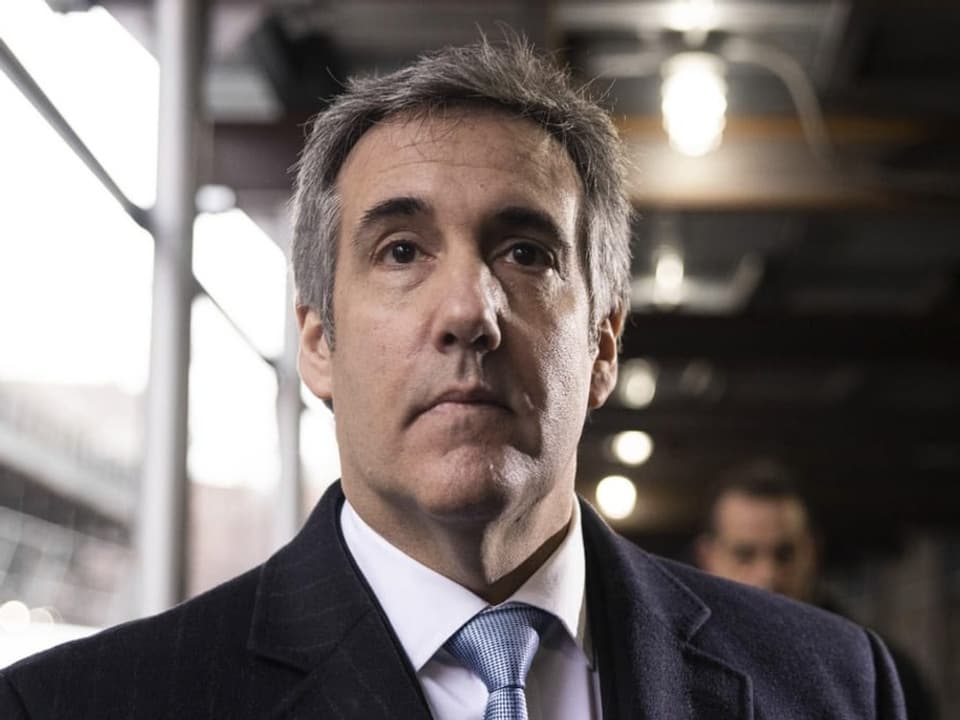 Cohen träge einen Anzug mit hellblauer Kravatte.