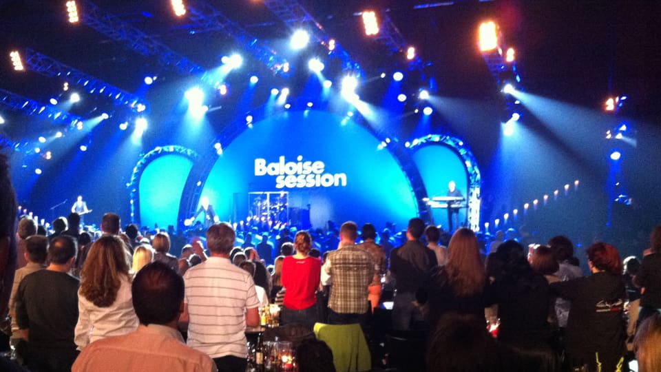 Die Bühne mit dem Logo Baloise Session, im Vordergrund Zuschauer.