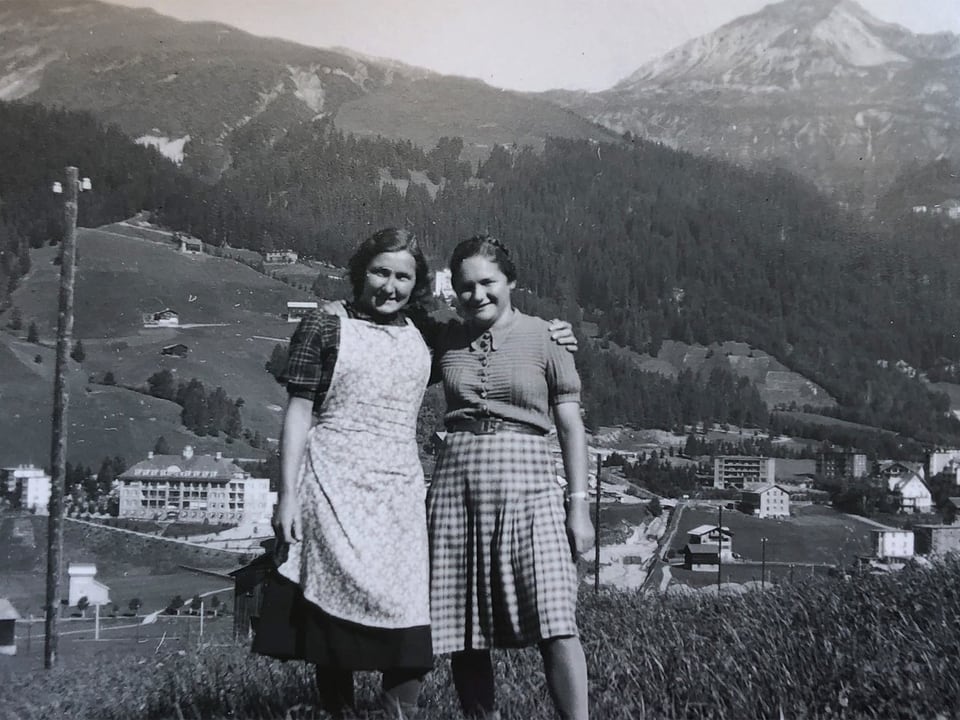 Zwei Frauen auf einer Wiese in den Bergen.