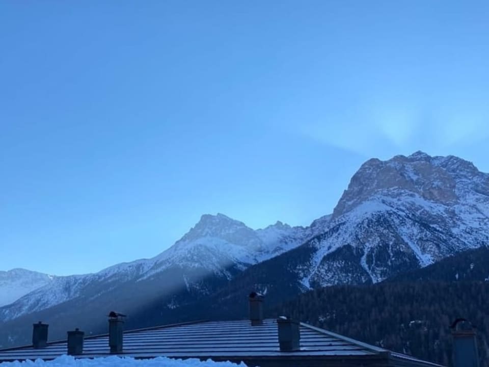 Die Sonne steigt langsam hinter dem Berg auf.