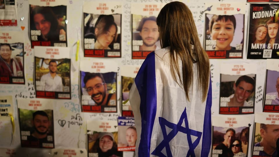 Eine Frau blickt auf die aufgehängten Bilder von von der Hamas entführten Israelis