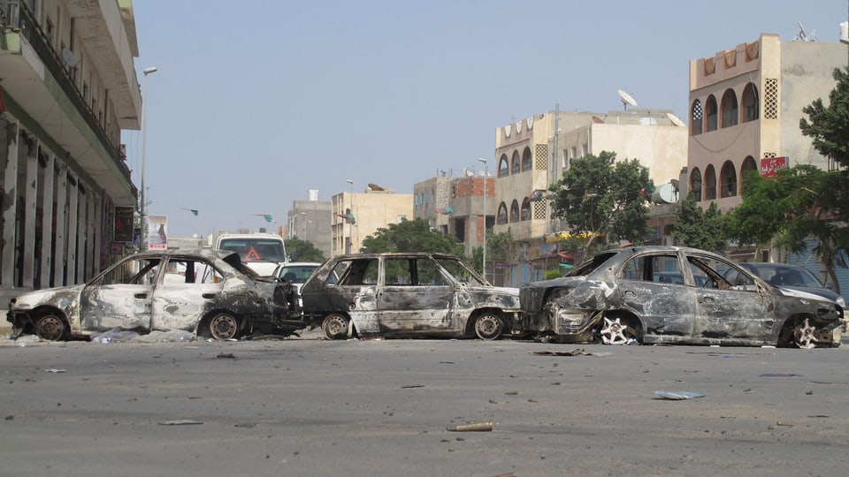 Drei ausgebrannte Autowracks nach Unruhen auf einer Strasse in Tripolis