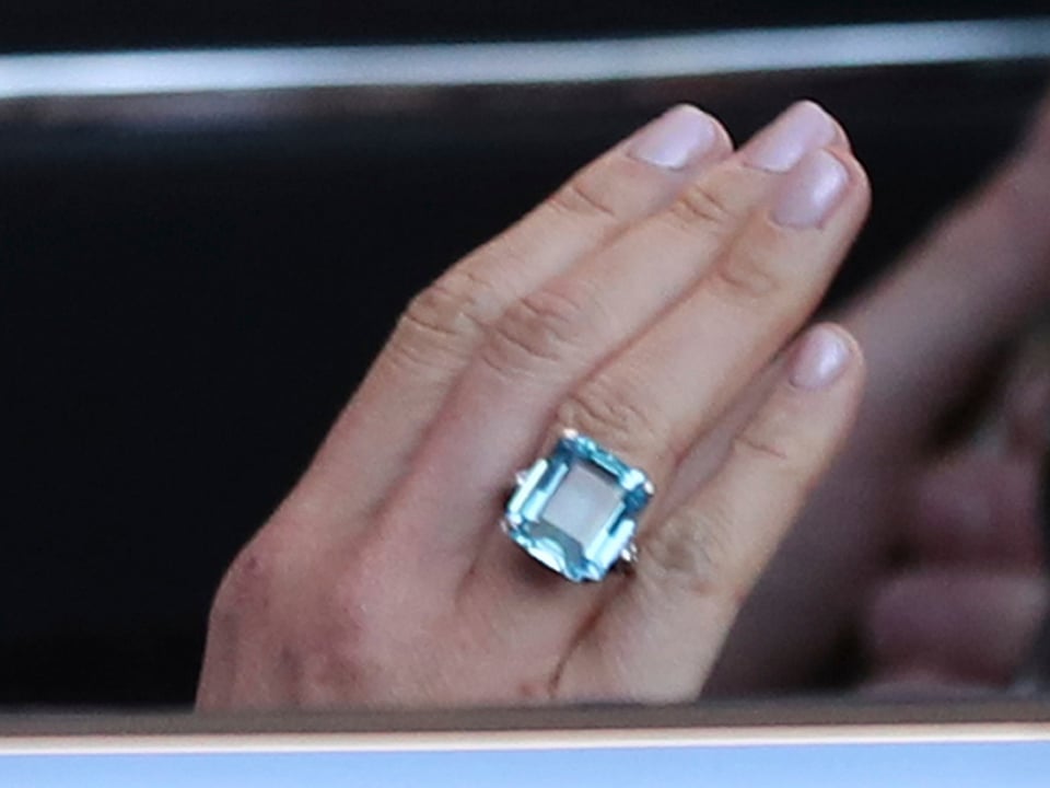 Nahaufnahme eines Ringes mit blauem Edelstein an Meghan Markles Hand. 