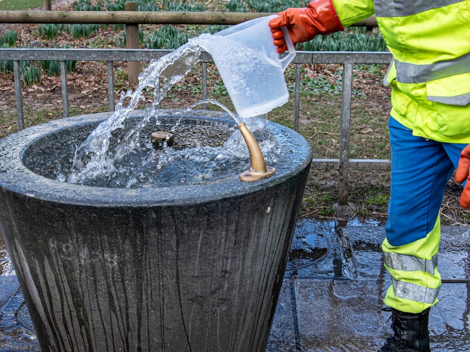 Mann reinigt einen kleinen Brunnen