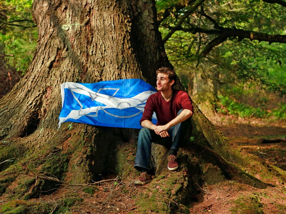 Student Lewis MacAskill posiert mit seiner Unabhängigkeitsflagge in einem Waldstück von Stornoway. (reuters)