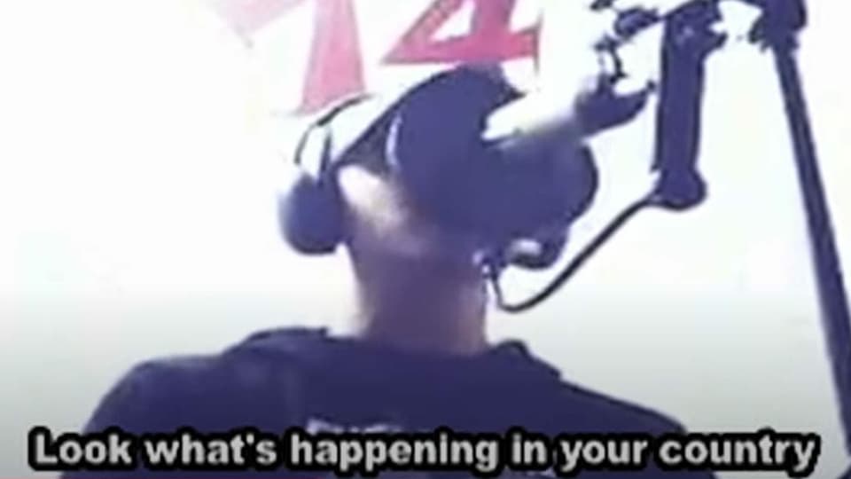 Rapper verdeckt sein Gesicht hinter Mikrofon