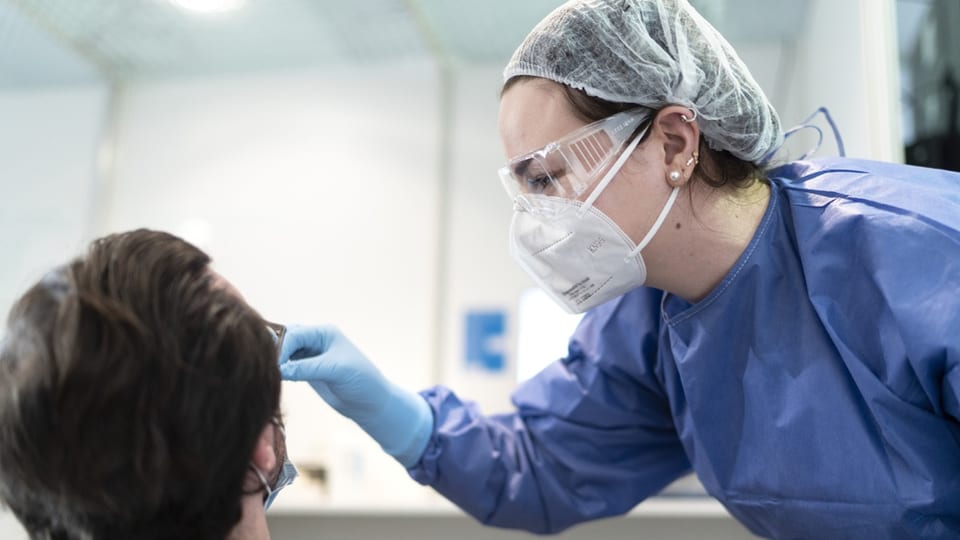 Eine Medizinerin testet einen Mann auf das Corona-Virus.