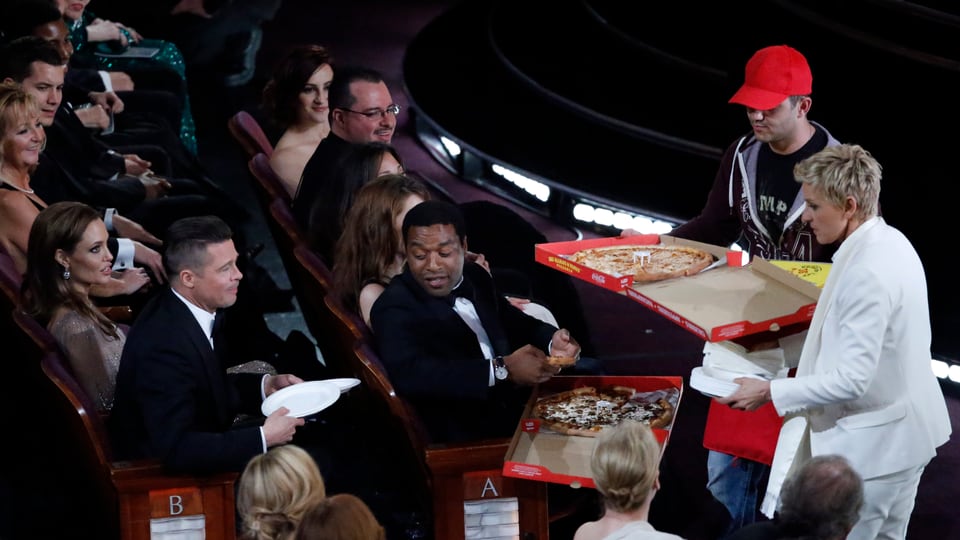 Ellen DeGeneres in den Publikumrängen eine Pizza verteilend.
