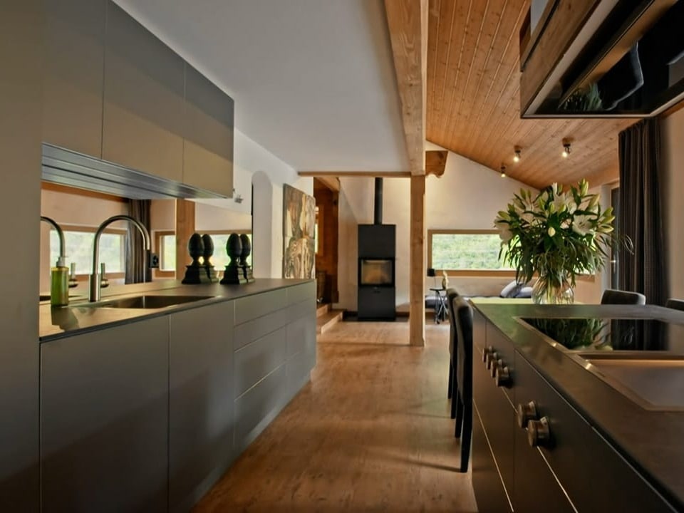 Ein hochmoderne Küche in schwarz in einem hellen Raum.