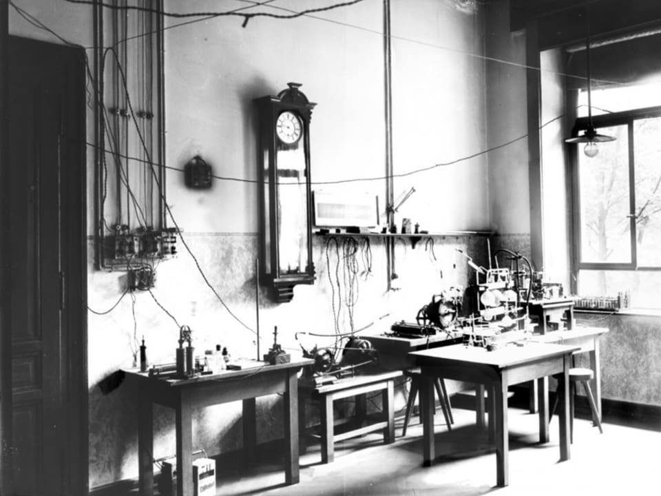 Historische Schwarzweissaufnahme eines mit Holztischen eingerichteten Labors.