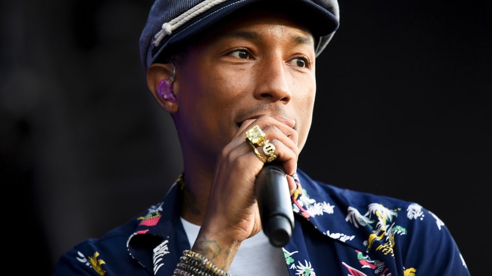 Pharrell Williams mit Hawaihemd und Schiebermütze. 