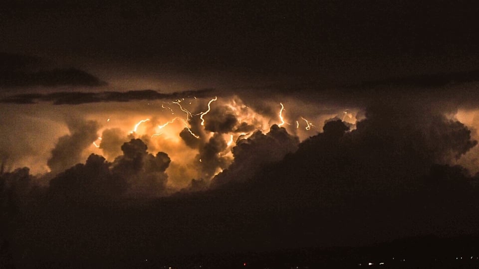 In der dunklen Nacht durch Blitze erhellte Cumulonimbus-Wolken