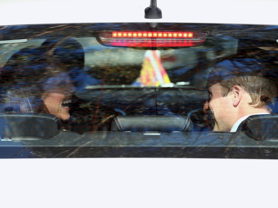Prinz William und Kate sitzen im Auto und lachen.