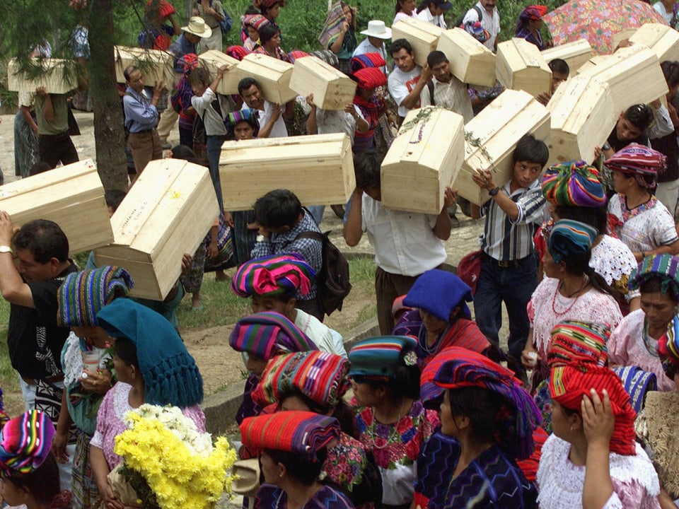 Angehörige der Ixiles tragen symbolische Särge.
