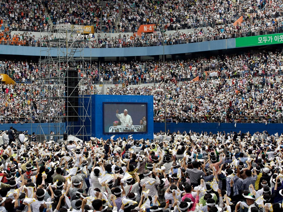 Der Papst auf einem grossen Bildschirm in einem Stadion.