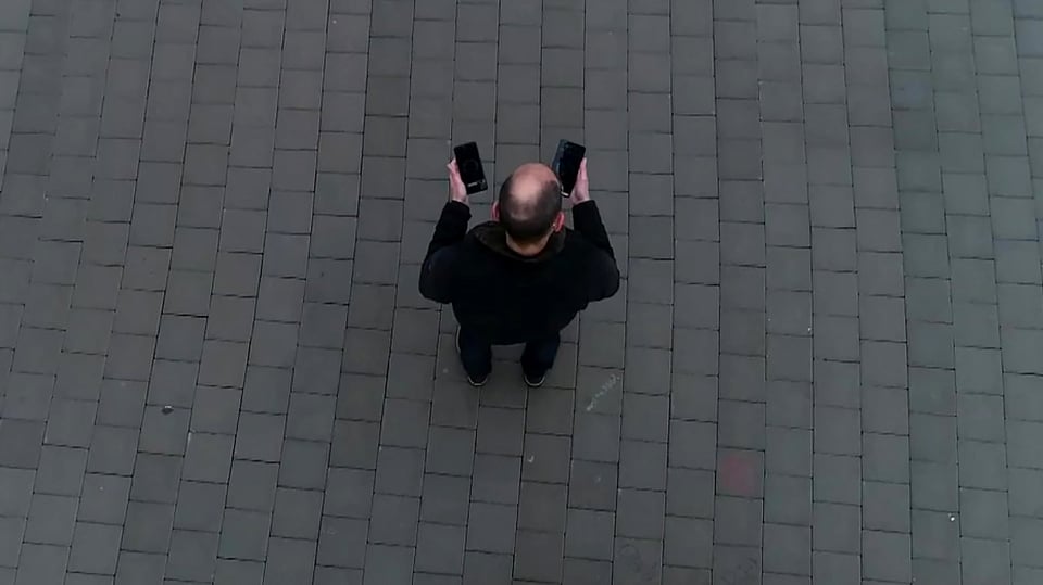 Digitalredaktor Reto Widmer von oben aufgenommen, zwei Smartphones in der Hand.