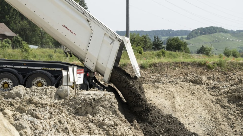 Lastwagen kippt Erde aus.