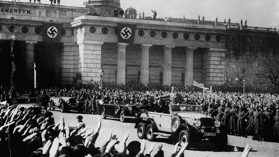 Hitler fährt 1938 mit seiner Wagenkolonne durch Wien.