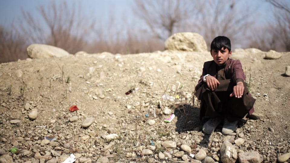 Ein Junge sitzt da, wo Khabir vor einem Jahr erschossen worden ist.