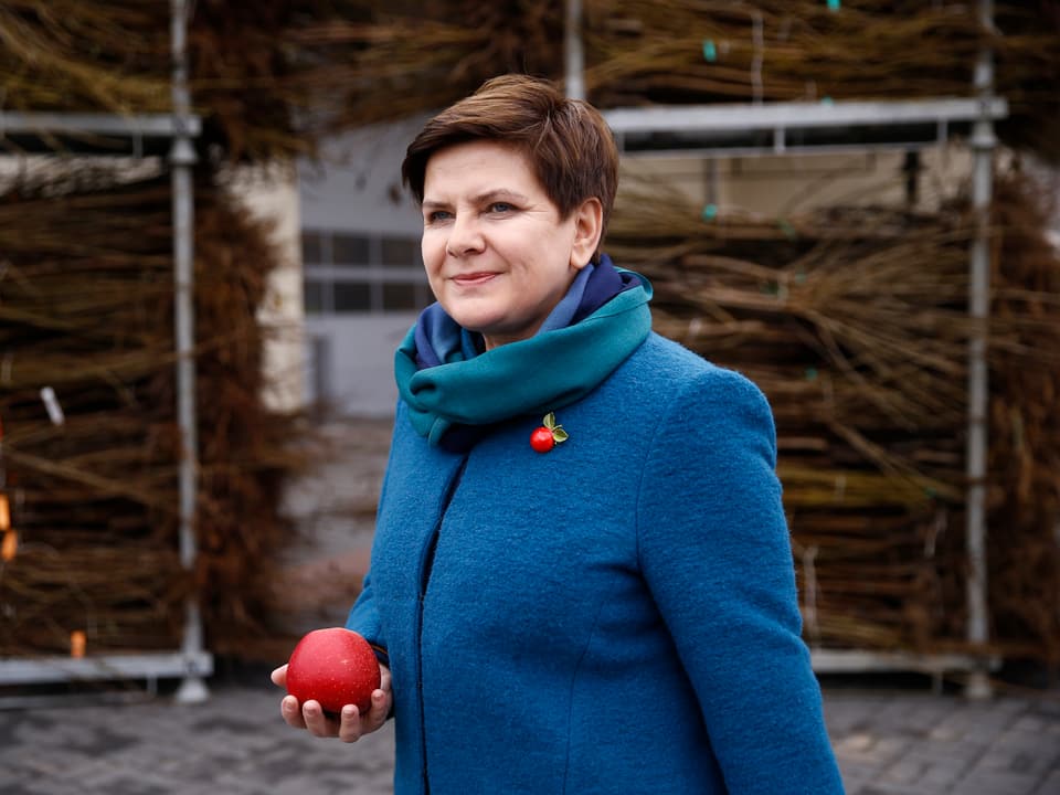 Die Politikerin Beata Szydlo hält einen Apfel in der Hand
