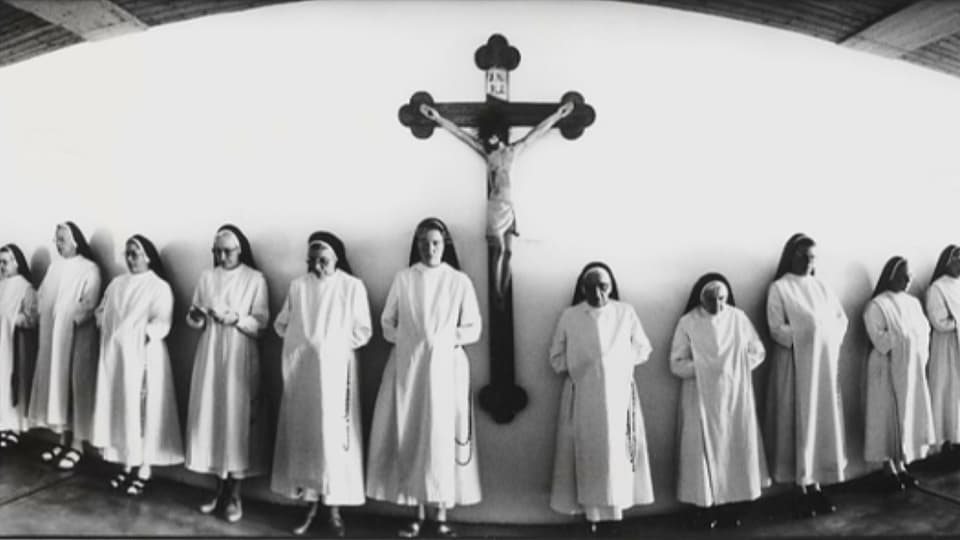 Eine schwar-weisse Fotografie von Nonnen, die aufgereiht nebeneinander stehen.