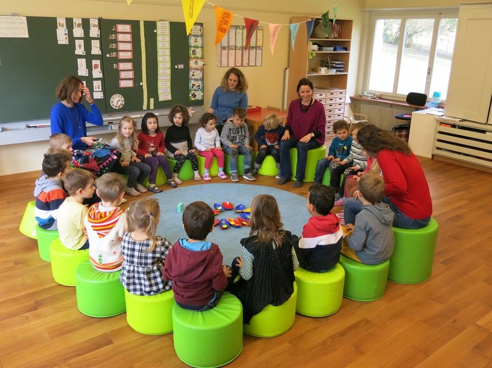 Kindergartenkinder sitzen in einem Kreis